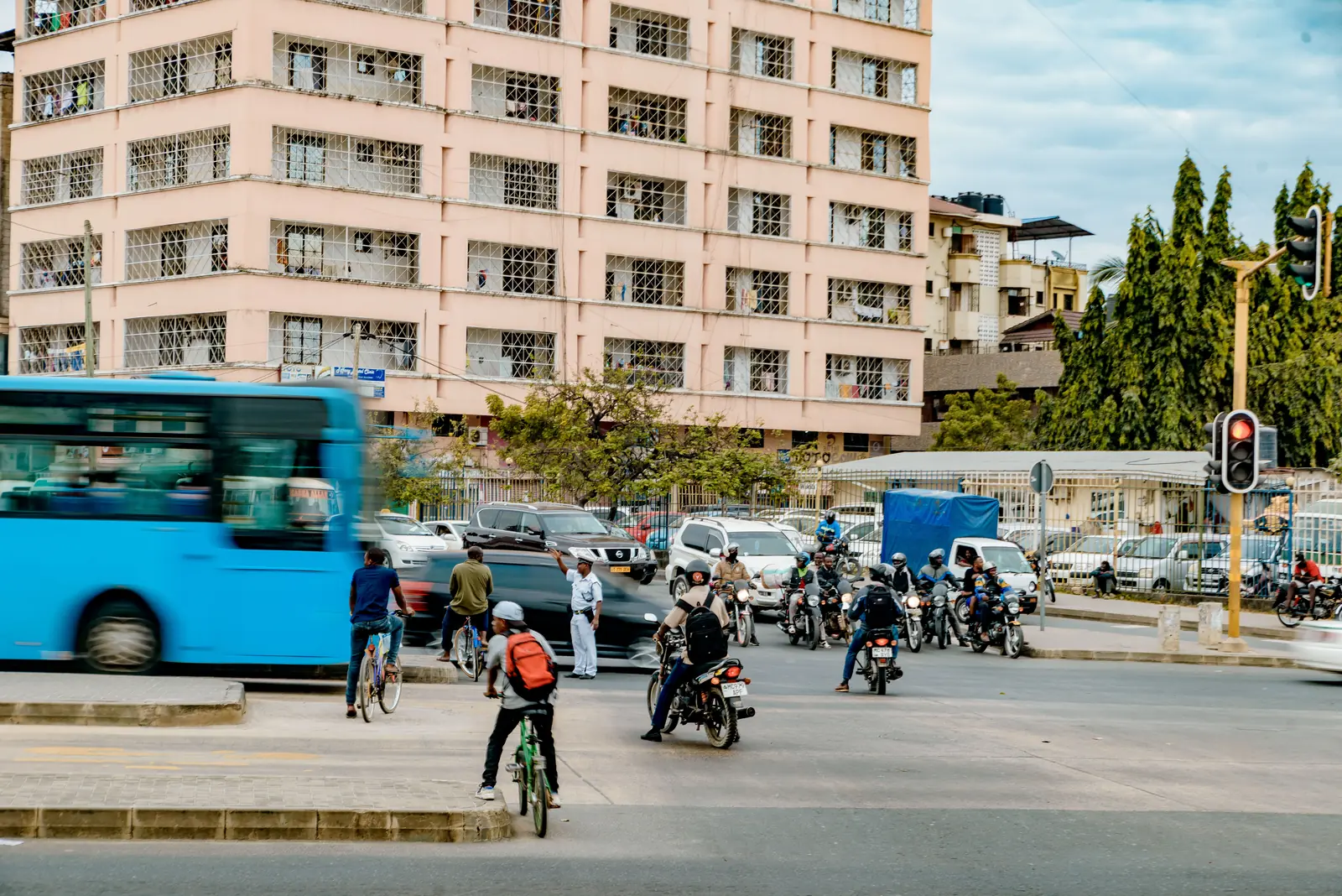Traffic at a junction in Dar es Salaam with a rapid transit bus, motorcycles and a cyclist